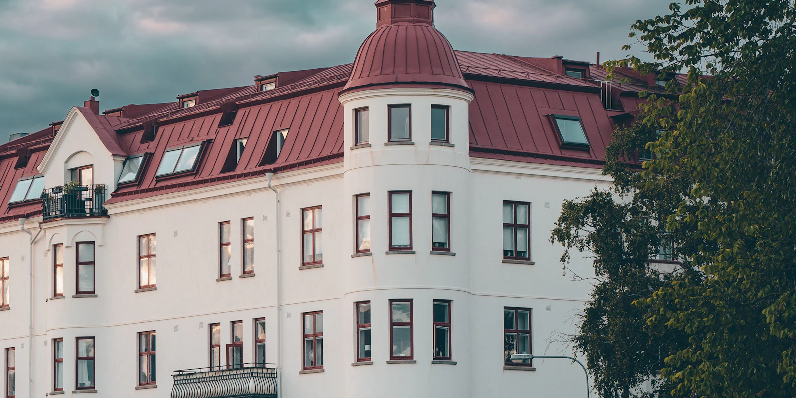 Ett flerbostadshus mot en molnig himmel i Kalmar.